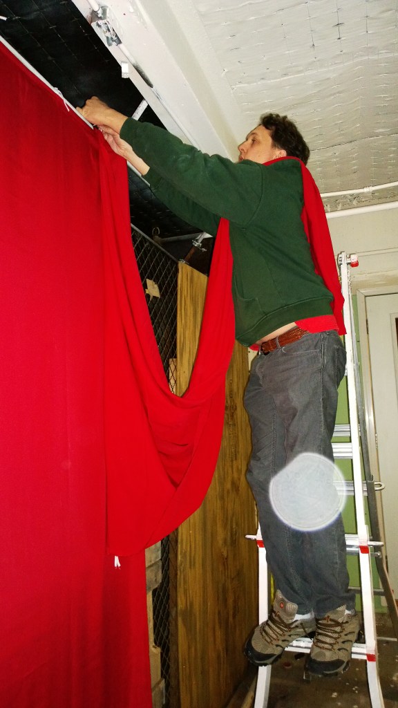 Kevin hangs curtains.